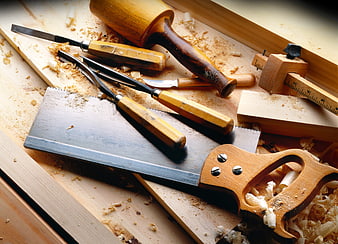 Woodworking tools on wooden workbench with sawdust