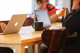 People working on laptops in a cafe with coffee