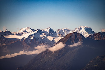 Majestic Snow-Capped Mountain Peaks with Clouds and Blue Sky