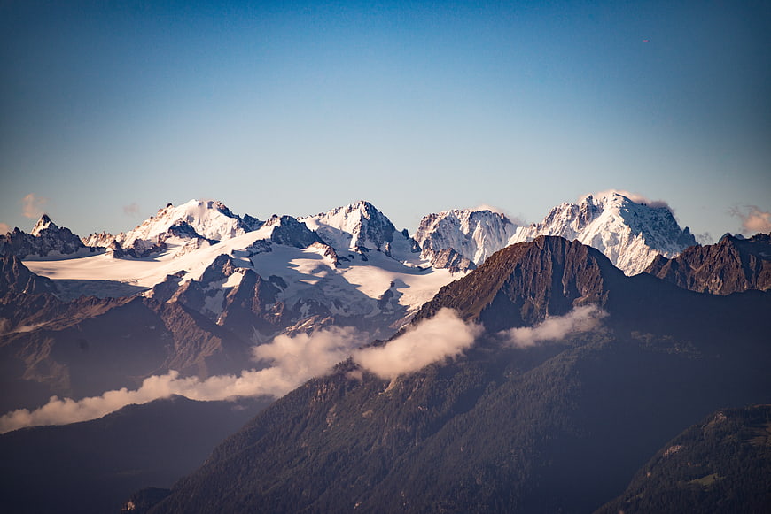 Majestic Snow-Capped Mountain Peaks with Clouds and Blue Sky