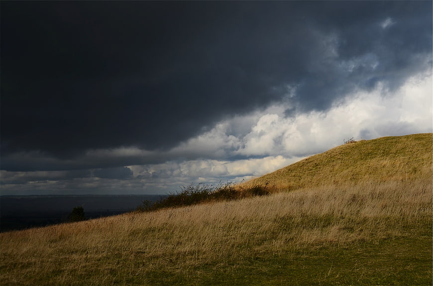 Dramatic Storm Clouds Over Grassy Hillside Landscape