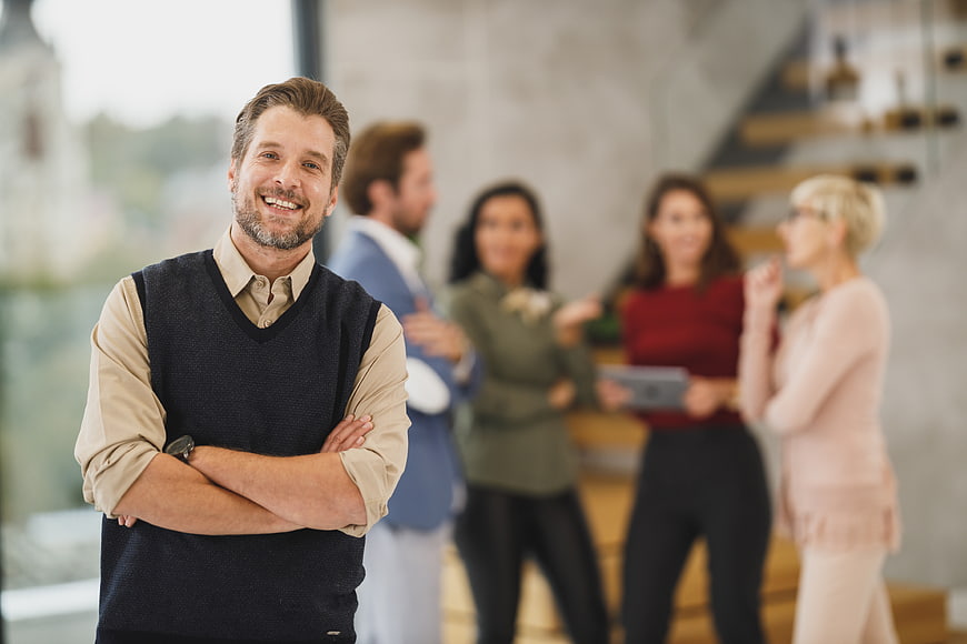 Smiling Businessman with Team in Modern Office