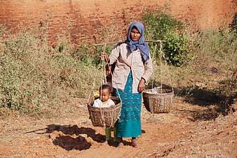 Burmese Mother Carrying Child In Basket On Shoulder Pole
