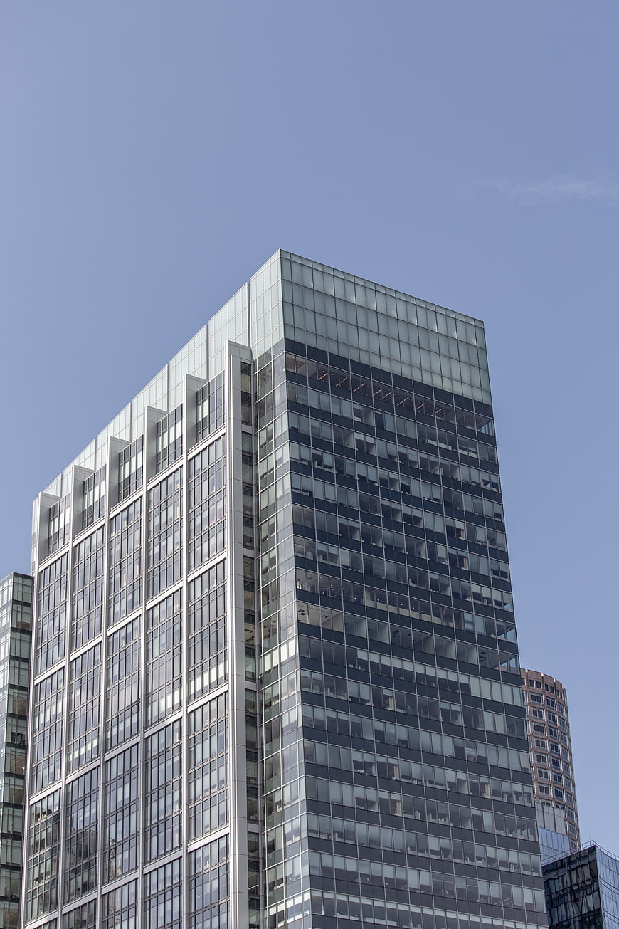 Modern Glass Office Building Against Blue Sky