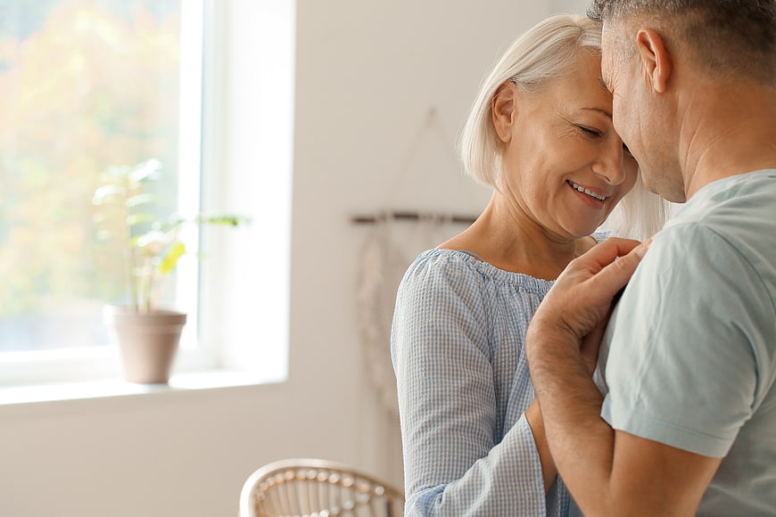 Senior couple embracing affectionately in bright home interior