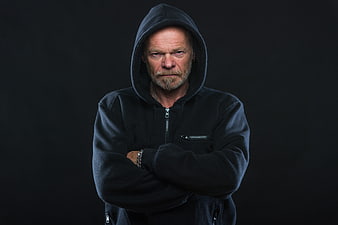 Portrait of serious senior man in black hoodie