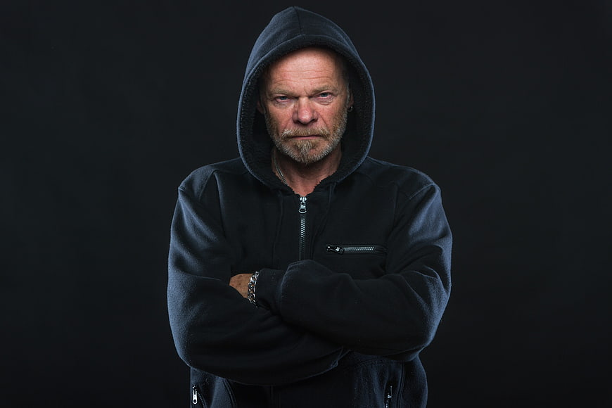 Portrait of serious senior man in black hoodie
