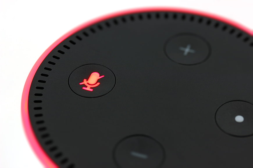Close-up of Amazon Echo Dot with glowing red microphone button