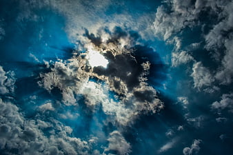 Dramatic Sun Rays Breaking Through Dark Blue Clouds