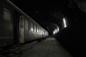 Old train carriage parked in dark underground tunnel
