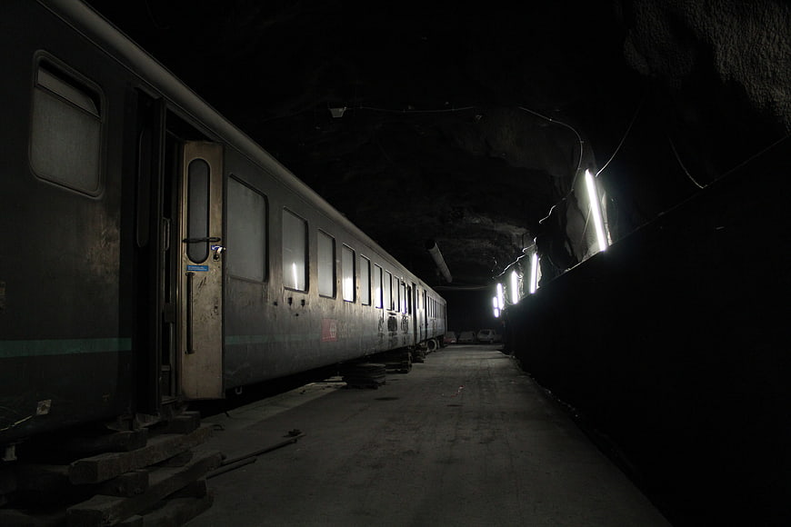 Old train carriage parked in dark underground tunnel