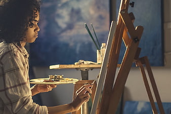 Young Woman Artist Painting on Canvas in Studio
