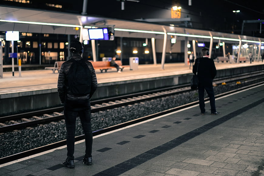 Two Men Waiting at Night Train Station Platform