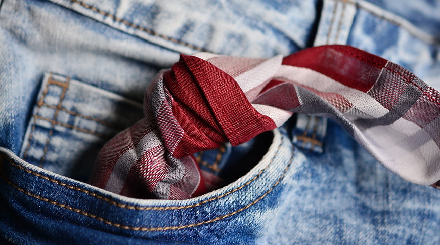 Red plaid handkerchief tucked in denim pocket