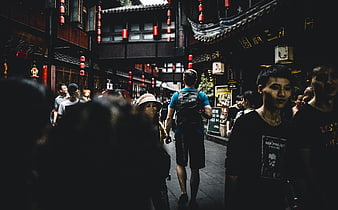 Crowded traditional Chinese street with red lanterns and tourists