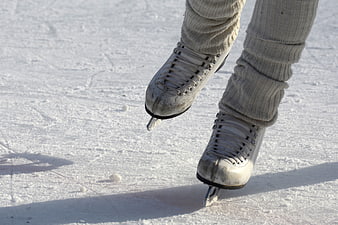 Close-up of worn white ice skates on outdoor rink