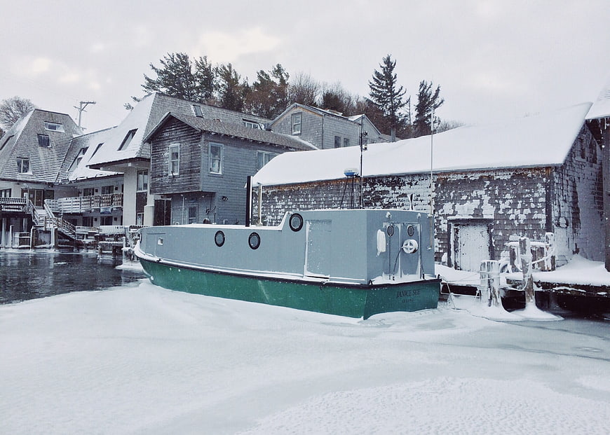 Frozen Harbor with Boat and Snowy Buildings