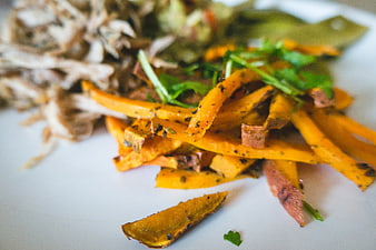 Close-up of roasted sweet potato fries with herbs