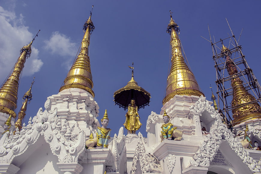 Golden Thai Temple Spires Against Blue Sky