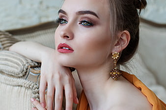 Elegant Woman with Gold Earrings and Makeup