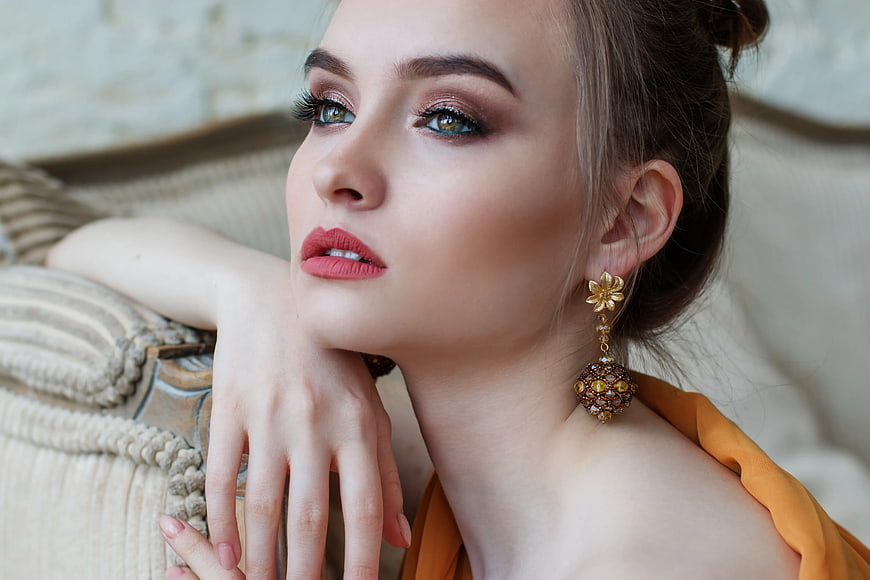 Elegant Woman with Gold Earrings and Makeup