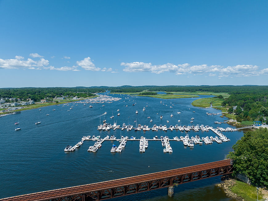 Aerial view of busy marina with boats and rusty bridge