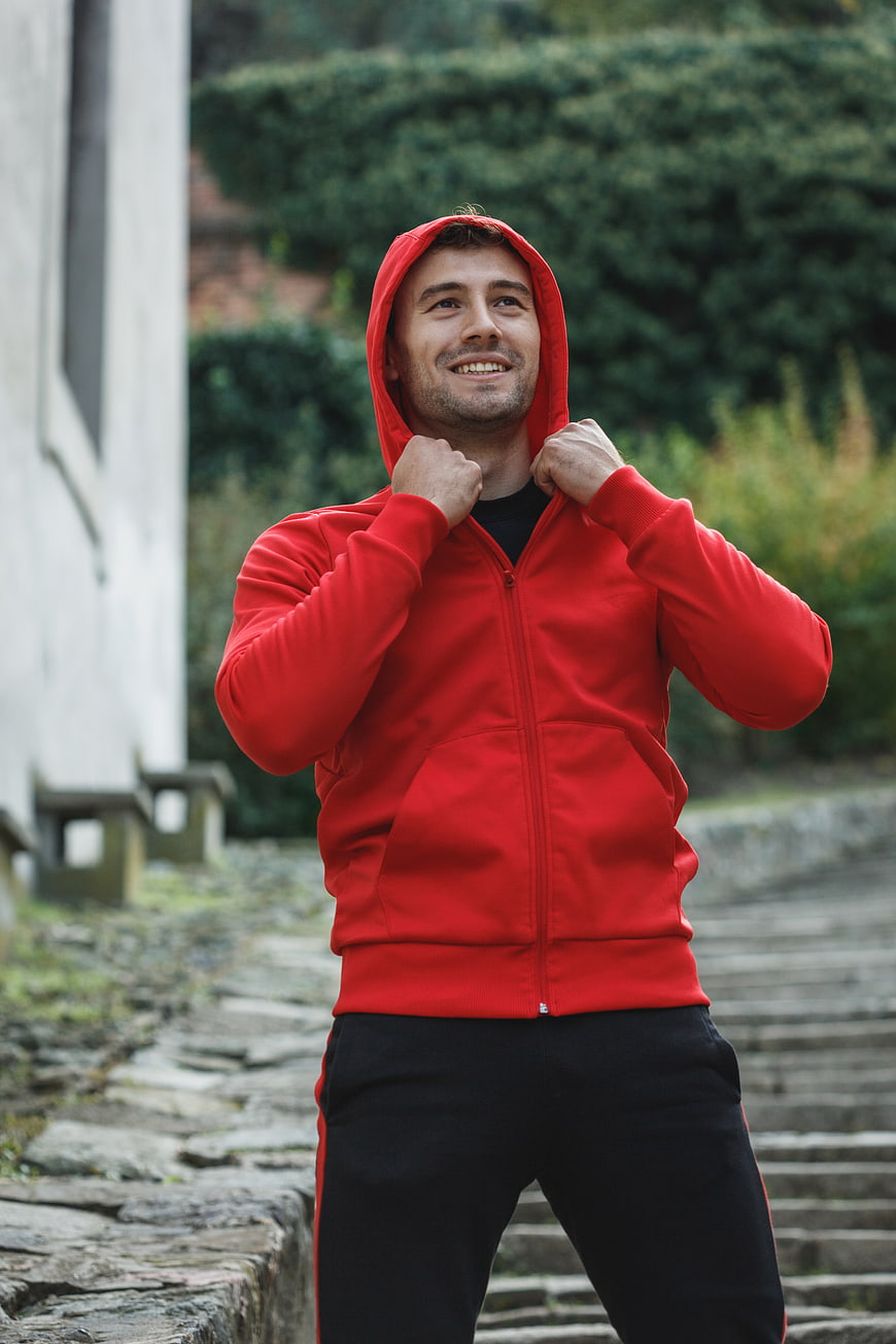 Happy Man in Red Hoodie Standing Outdoors
