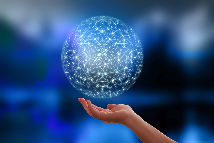 Hand holding glowing digital network globe against blue background