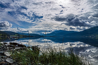 Dramatic Cloudy Sky Reflected in Calm Mountain Lake