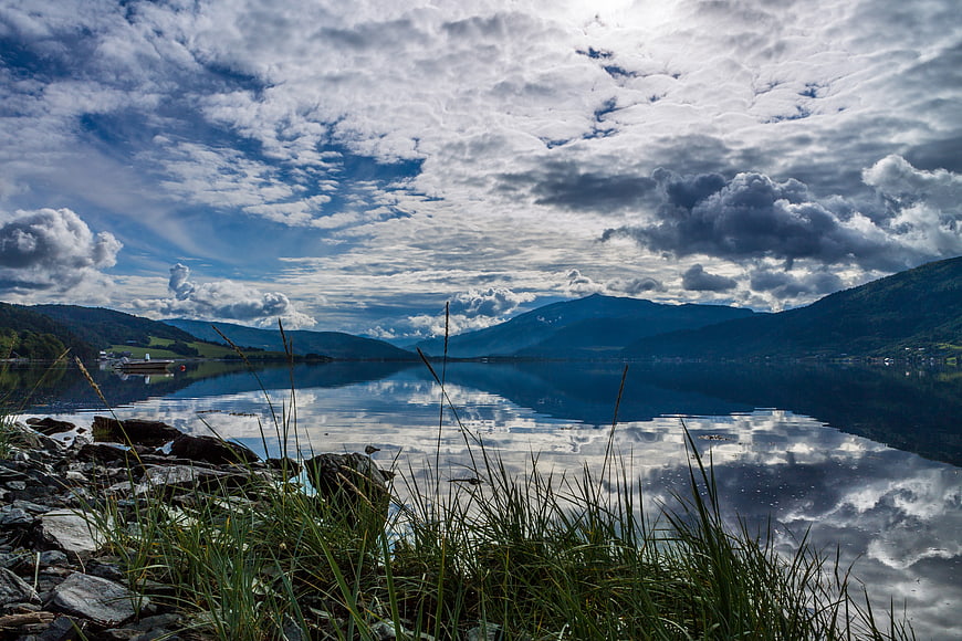 Dramatic Cloudy Sky Reflected in Calm Mountain Lake