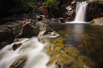 Long Exposure Waterfall Flowing Over Rocks in Forest