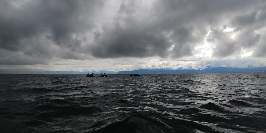 Dramatic stormy lake with small boats under dark clouds