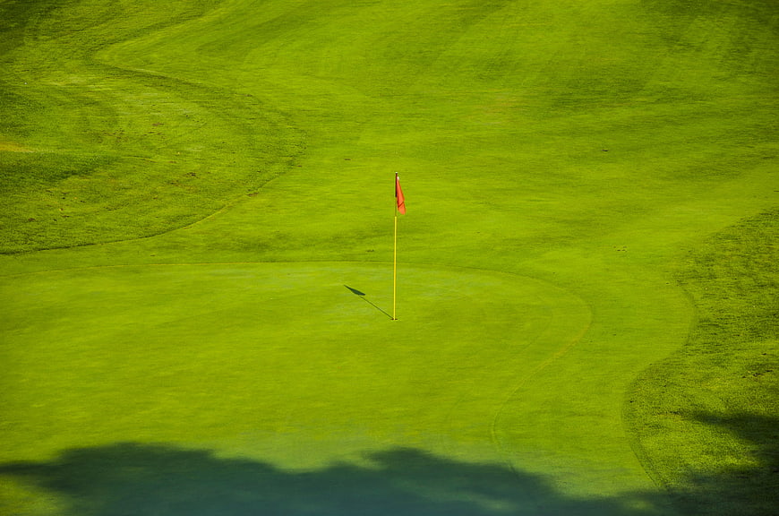 Aerial View of Golf Course Green with Red Flag