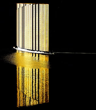 Golden skyscraper reflection in water at night