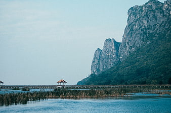 Serene Lake with Wooden Bridge and Limestone Mountains