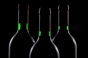 Three Dark Wine Bottles with Green Foil Accents