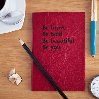 Red Notebook with Inspirational Quote on Wooden Desk