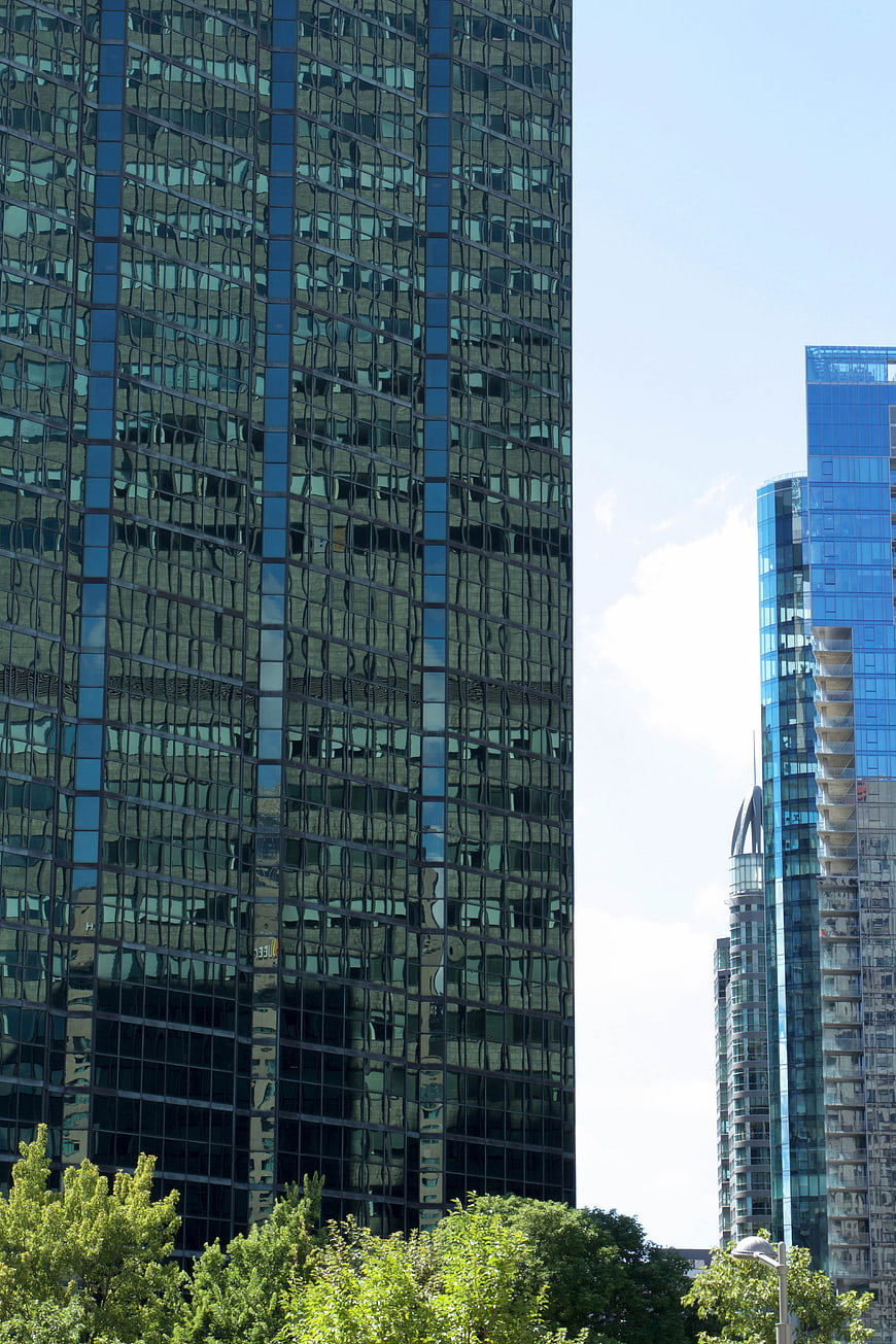 Modern Glass Skyscrapers with Blue Reflections and Green Trees