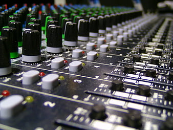 Close-up of professional audio mixing console with knobs and sliders