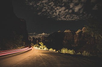 Long Exposure Night Road with Car Light Trails in Desert Canyon
