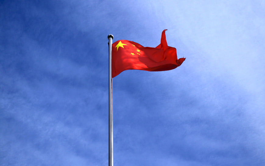 Chinese Flag Waving Against Blue Sky