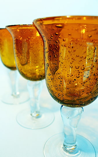 Close-up of three glasses of sparkling amber beverage