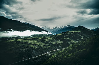 Dramatic Mountain Landscape with Mist and Winding Road