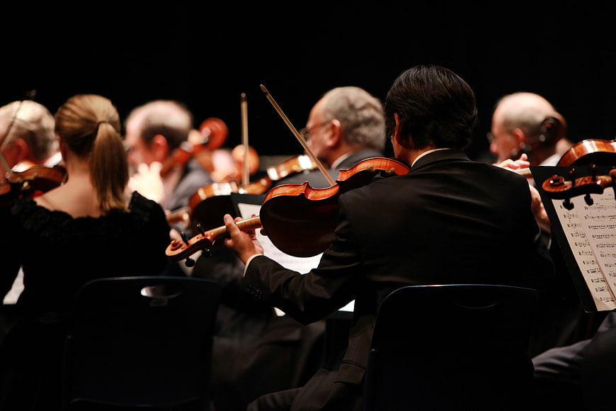 Orchestra Musicians Playing Violins on Stage