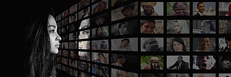 Woman looking at wall of diverse faces on screens