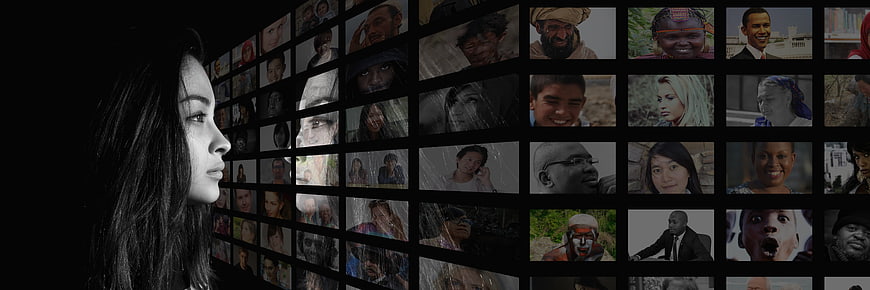 Woman looking at wall of diverse faces on screens