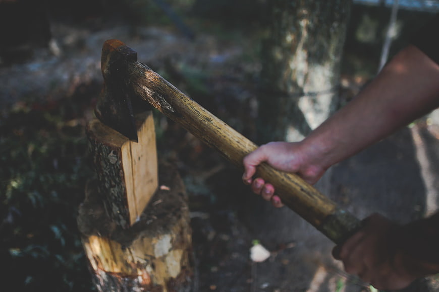 Man chopping wood with axe in forest