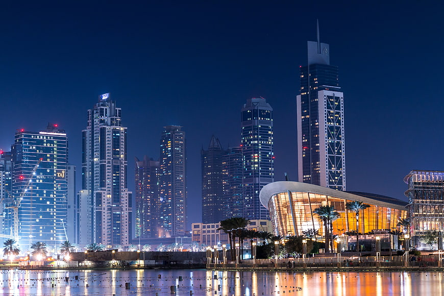 Doha skyline at night with modern skyscrapers and water reflections