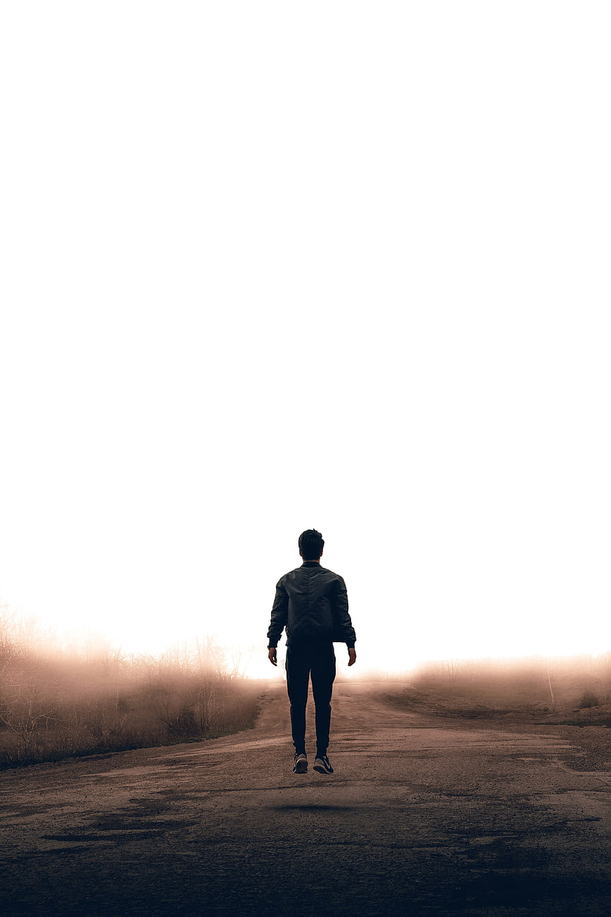 Man Jumping on Foggy Road at Sunrise