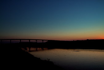 Silhouette of Bridge Over River at Sunset